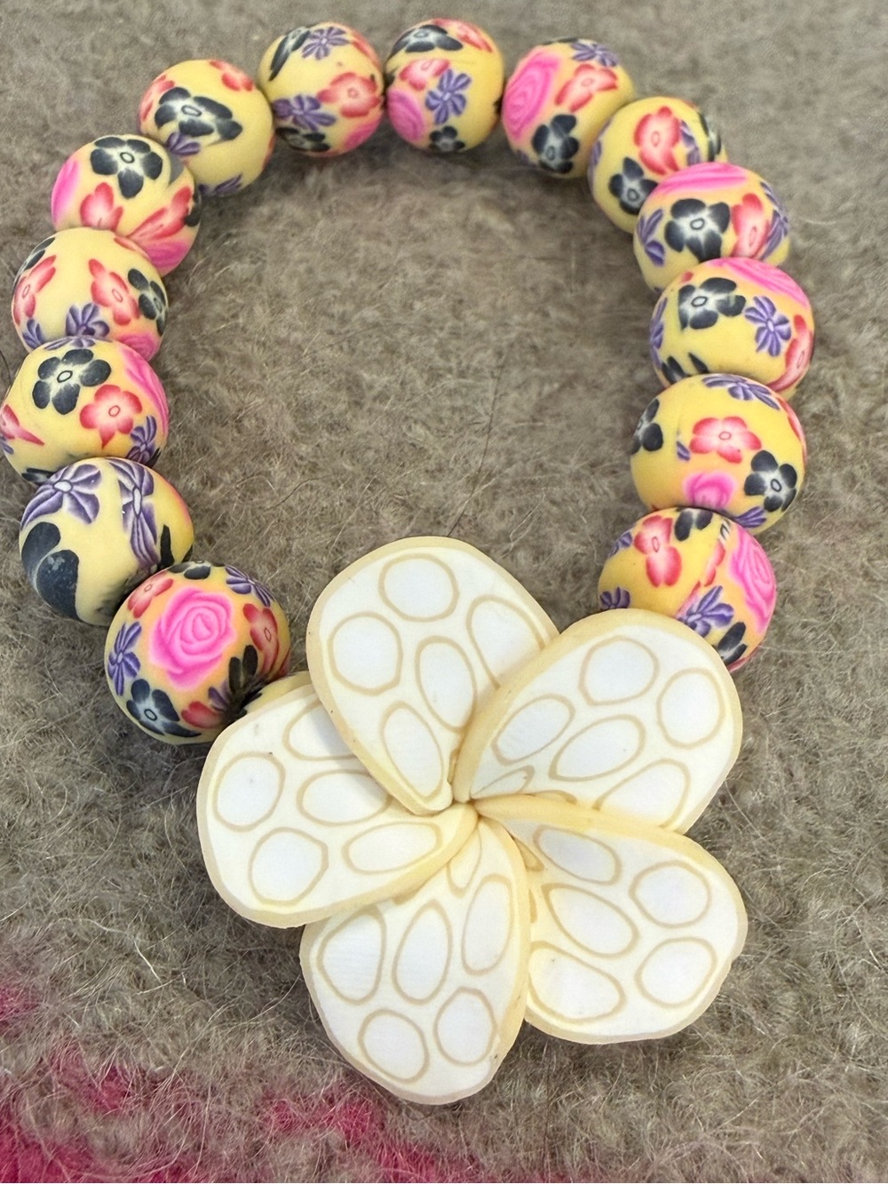 Floral beaded stretch bracelet with a tropical floral charm